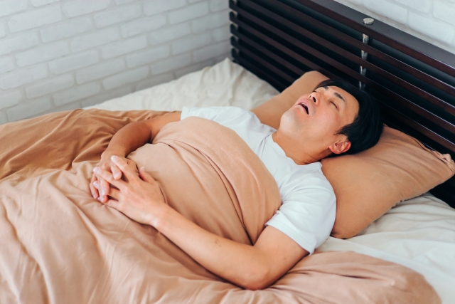 自宅のベッドで眠る男性のイメージ